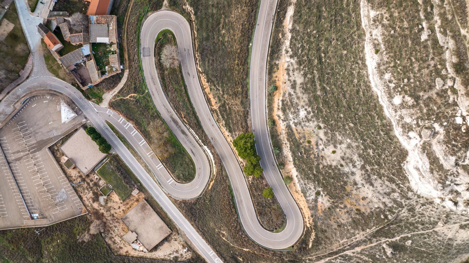 Puebla de la Sierra en camper: acceso y pernocta 1 Carretera de montaña estrecha con curva cerrada y muro bajo de piedra